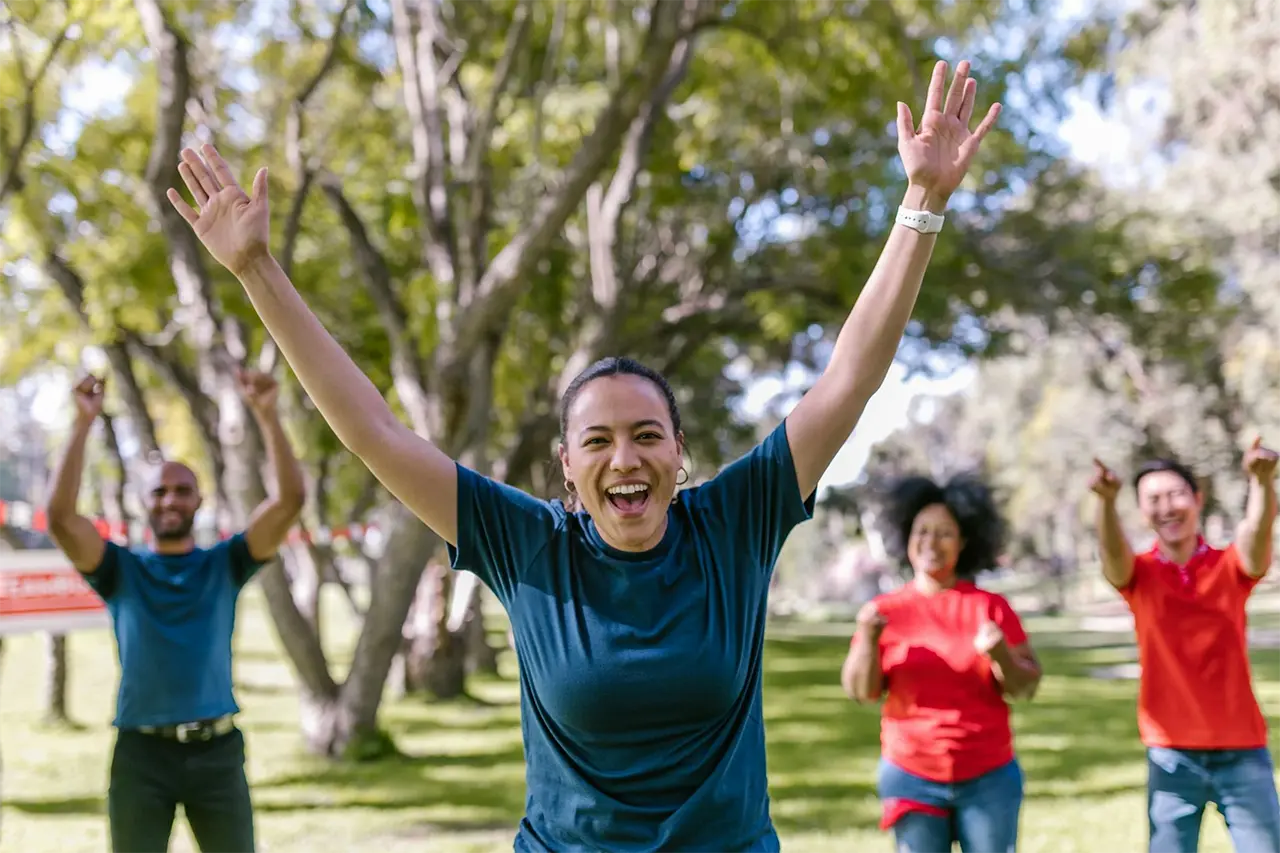 woman with arms outstretched with people in the background